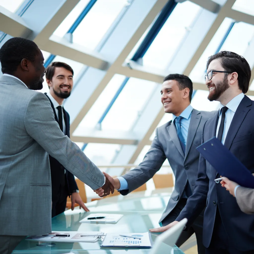 Business leaders shaking hands during a prepare for the win workshop conversation.